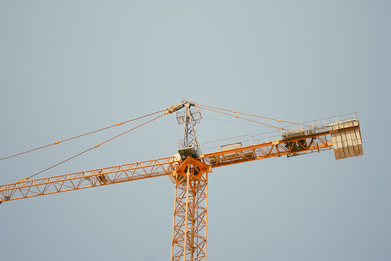 a yellow crane is against a blue sky